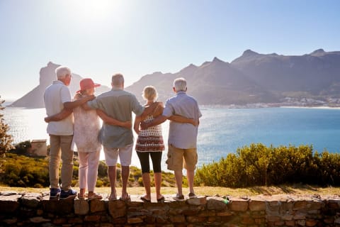 Group of senior travelers in looking at the bay surrounded by mountains in Cape Town, South Africa